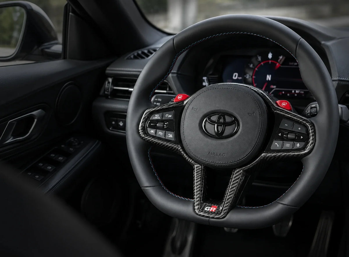Illustrative custom steering wheel in a Toyota GR Supra cockpit. Rendered preview, not a finished wheel.